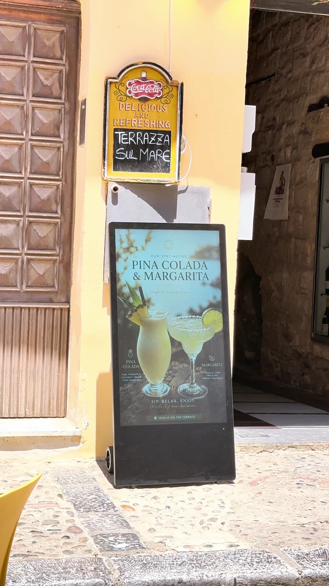 Il totem mostra una creatività con due cocktail chiari su fondo scuro.