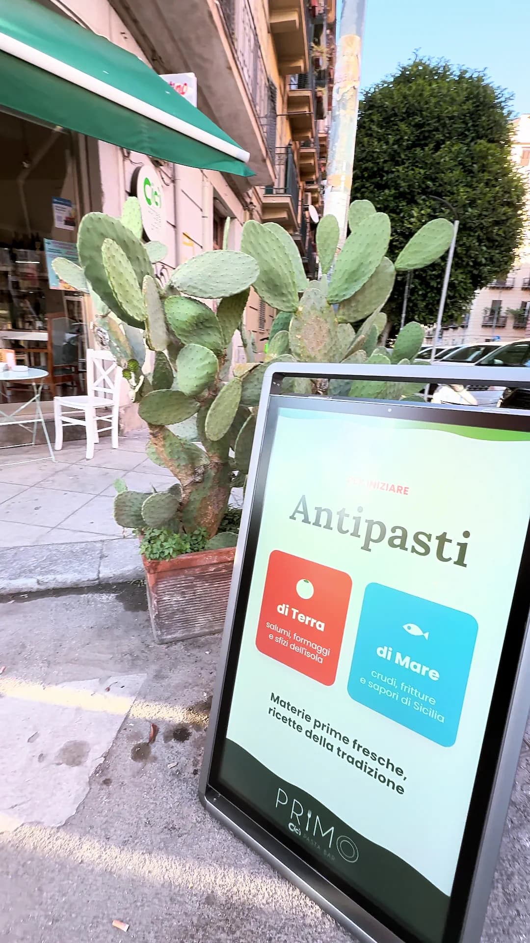 Il totem ripreso frontalmente mentre mostra la sezione antipasti; alle spalle la terrazza del ristorante.